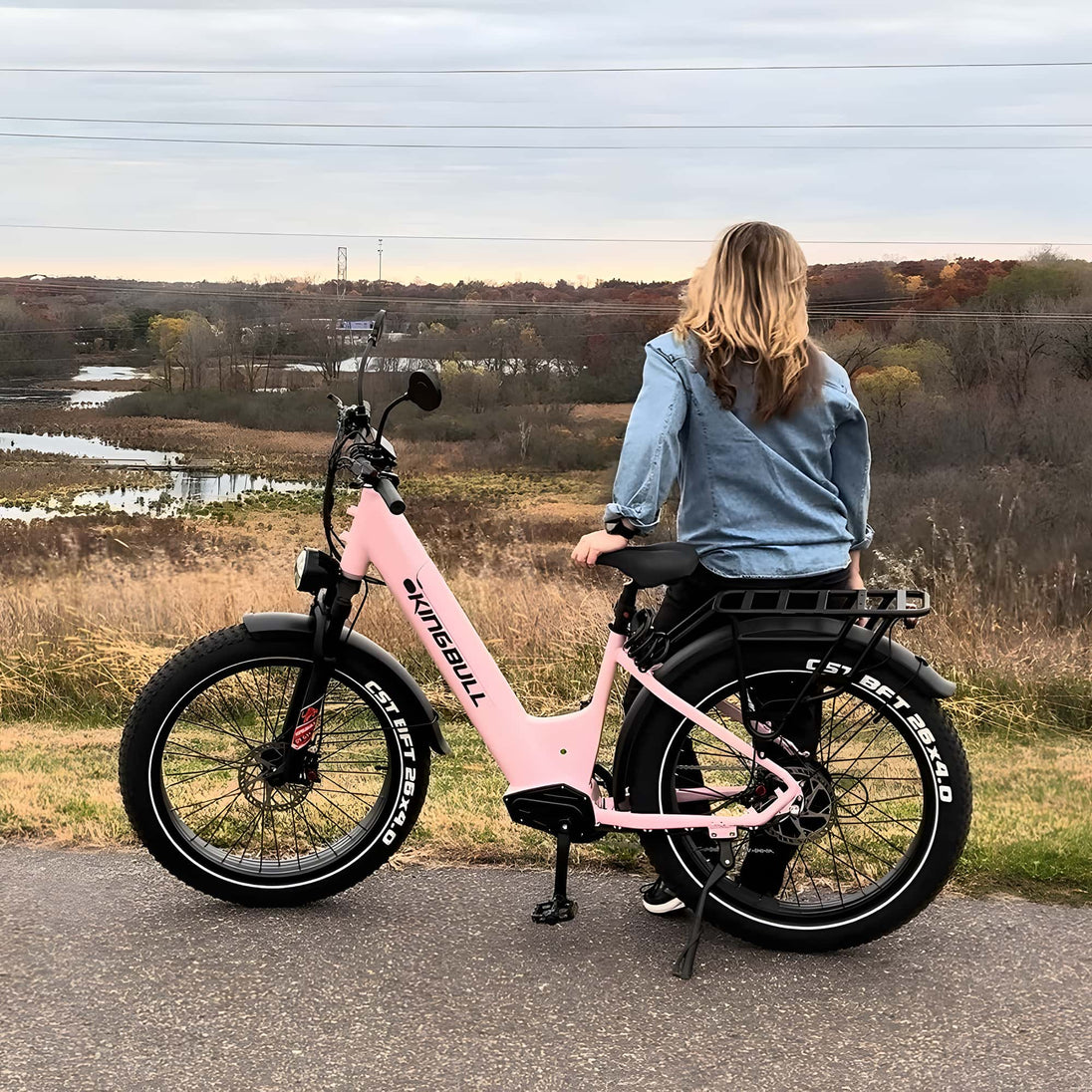 A pink Kingbull electric bike is parked in the trail.