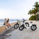 A couple parked their kingbull electric bikes next to rest by the sea