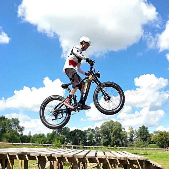 A cyclist on a Kingbull EX Titan golden e-bike jumping off a wooden ramp.