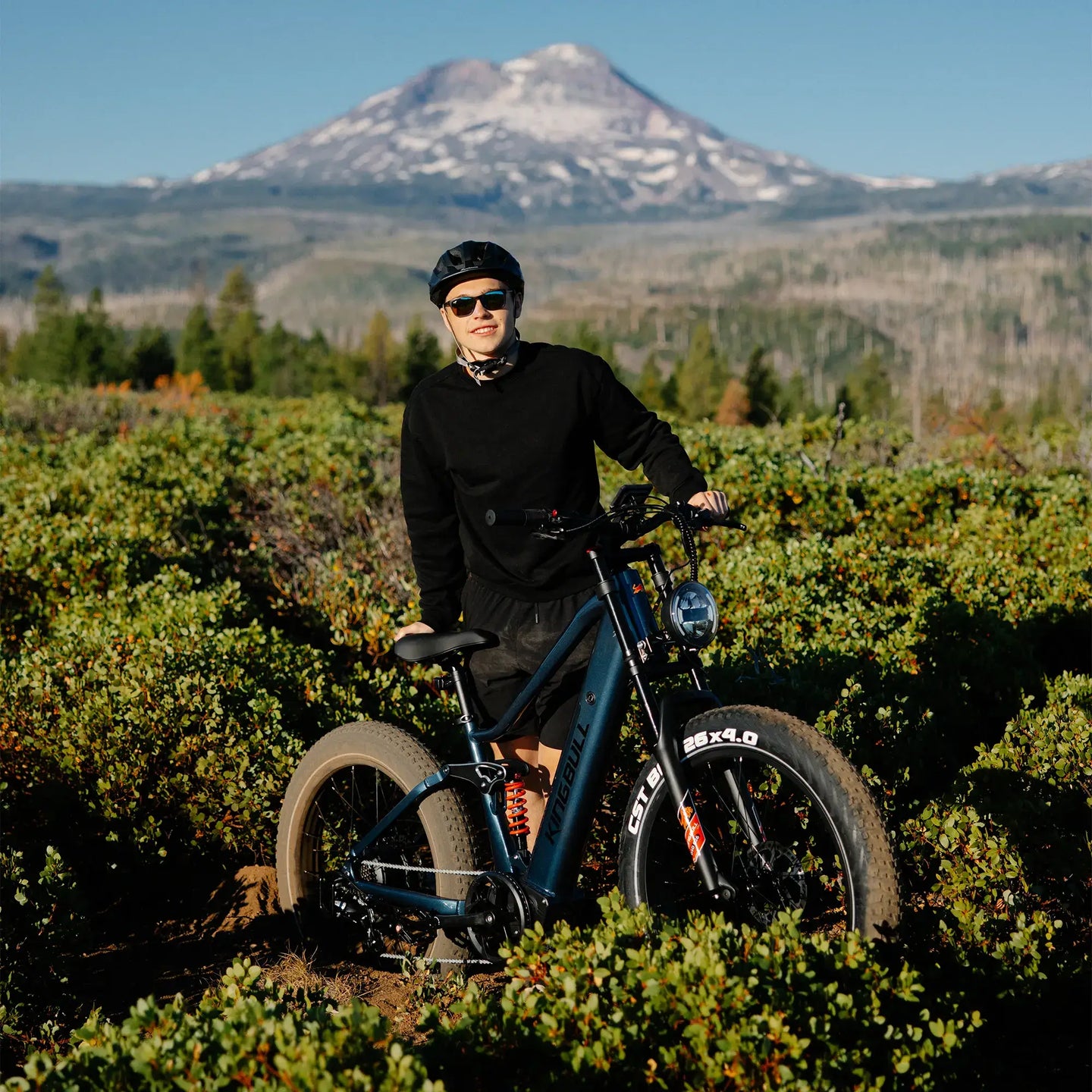 Man cycling the Kingbull rover2.0 e-bike in the grass and smiling.