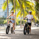 A man is riding a kingbull electric bike in the city with a lady